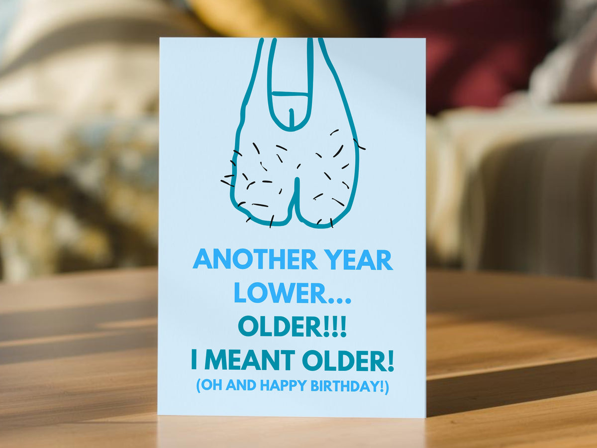 A funny birthday card that shows a drawing of sagging balls with the words 'ANOTHER YEAR LOWER.... OLDER!!! I MEANT OLDER! (OH AND HAPPY BIRTHDAY!)