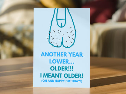 A funny birthday card that shows a drawing of sagging balls with the words 'ANOTHER YEAR LOWER.... OLDER!!! I MEANT OLDER! (OH AND HAPPY BIRTHDAY!)