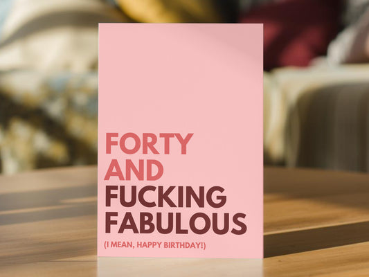A pink 40th birthday greeting card with bold text reading 'FORTY AND FUCKING FABULOUS (I MEAN, HAPPY BIRTHDAY!)